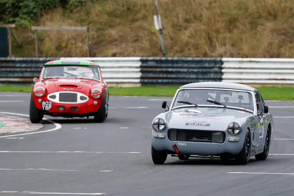 Number 217 Austin-Healey Sprite racing wheel to wheel at Castle Combe