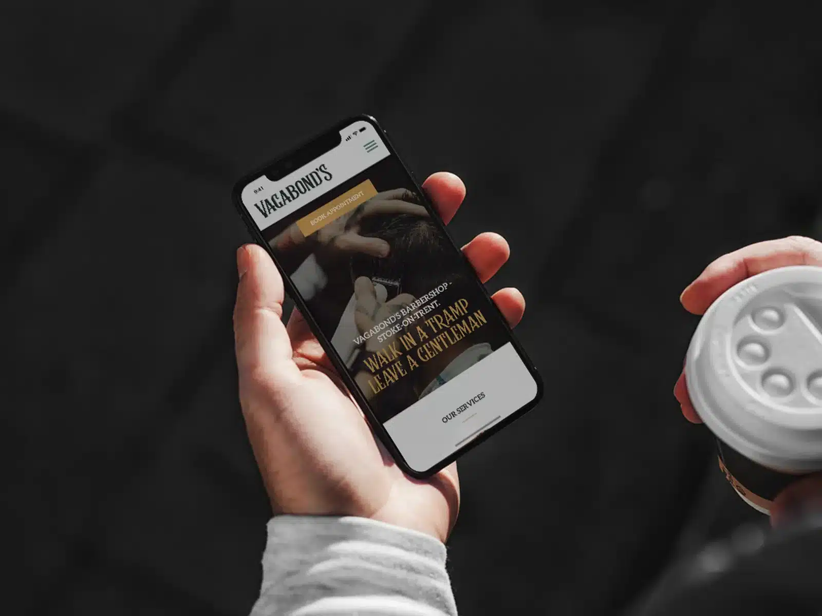 Barbershop website on a phone in hand Barbershop website on a phone in hand
