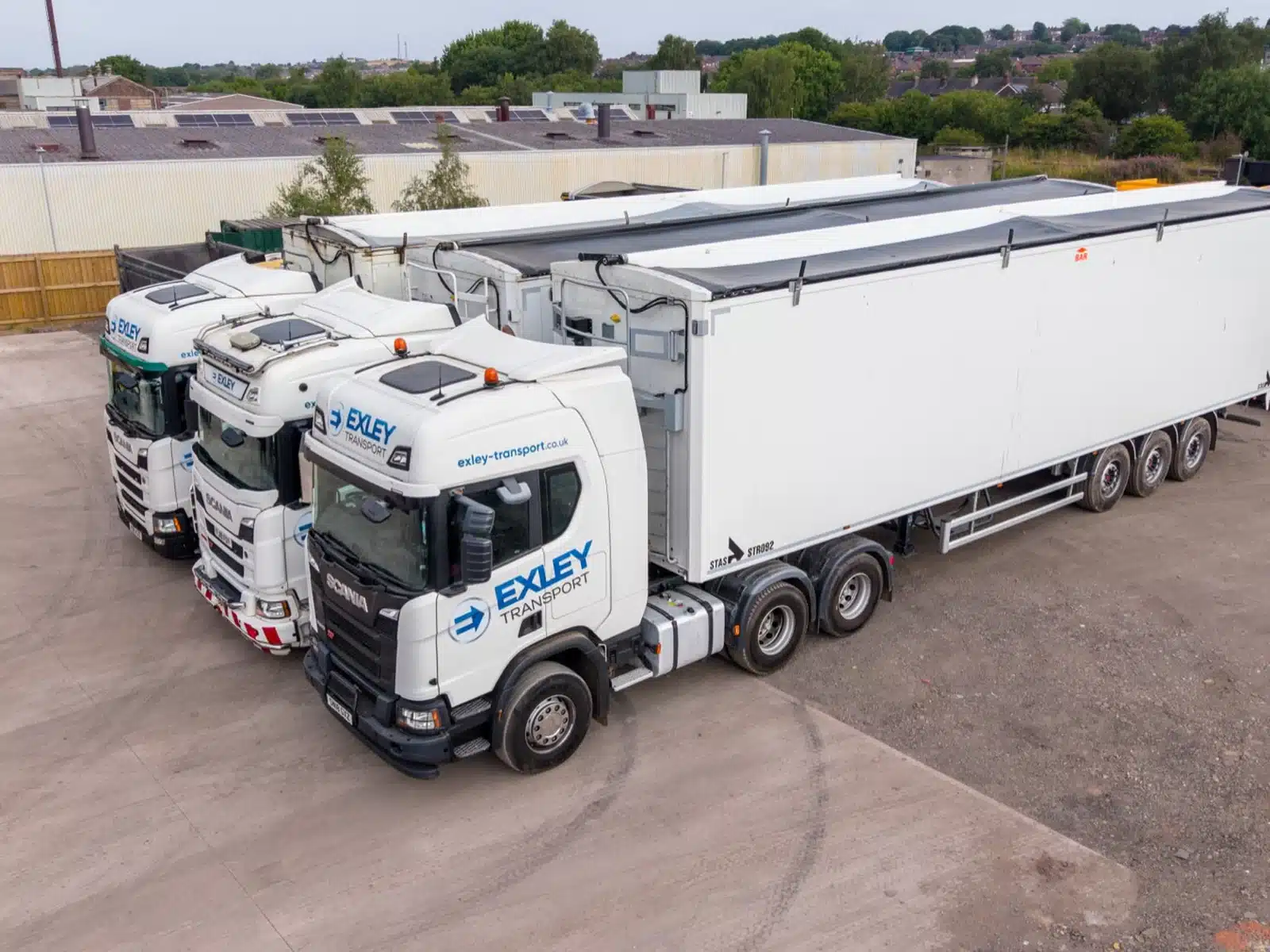 Fleet of liveried walking floor lorries in a yard in Stoke-on-Trent